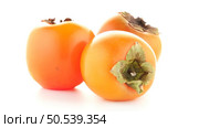 Red ripe persimmons rotating over white background. Стоковое фото, агентство Ingram Publishing / Фотобанк Лори