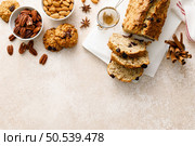 Fruitcake with cranberry, almond and pecan nuts sliced on a wooden board. Стоковое фото, агентство Ingram Publishing / Фотобанк Лори