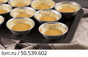 Egg tarts, traditional portuguese dessert, pastel de nata, custard tarts during home production on metal tray. Стоковое фото, агентство Ingram Publishing / Фотобанк Лори