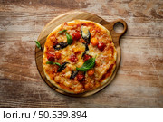 Pizza Margherita on a wooden background. Стоковое фото, агентство Ingram Publishing / Фотобанк Лори