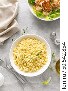 Couscous with chicken patties, cutlets with fresh romaine lettuce salad, top down view. Стоковое фото, агентство Ingram Publishing / Фотобанк Лори