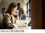 Young businesswoman and diverse group of business people working together in office, Brainstorming on how to use natural energy from wind and sunlight to offer customers. Стоковое фото, агентство Ingram Publishing / Фотобанк Лори