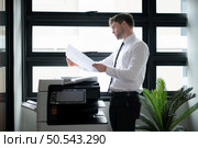 Businessman in office working with copier. Стоковое фото, агентство Ingram Publishing / Фотобанк Лори