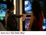 Both of young woman stand and watch the movie program to watch today. Стоковое фото, агентство Ingram Publishing / Фотобанк Лори