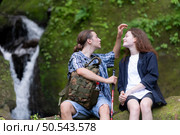 Young couple hiking in the forest with backpacks and trekking poles. Стоковое фото, агентство Ingram Publishing / Фотобанк Лори