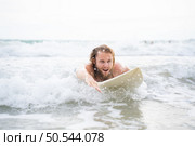 Young man surfing on the beach having fun and balancing on the surfboard. Стоковое фото, агентство Ingram Publishing / Фотобанк Лори