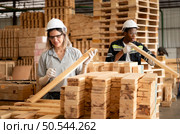 Young female and male warehouse workers using digital tablet for working in wooden factory, Checking the neatness of the planks. Стоковое фото, агентство Ingram Publishing / Фотобанк Лори