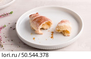Small croissants in white ceramic plates, homemade cakes on concrete table top. Стоковое фото, агентство Ingram Publishing / Фотобанк Лори