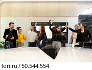 A group of multiracial businesspeople hands raise to celebrate success in front of the meeting room, indicating the concept of business success. Стоковое фото, агентство Ingram Publishing / Фотобанк Лори