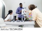 Group of multi-national team of architects and designers is meeting to brainstorm designs for wind turbines to capture wind energy and convert it into electrical energy. Стоковое фото, агентство Ingram Publishing / Фотобанк Лори