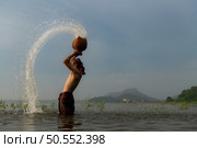 Fishermen using traditional fishing equipment After catching fish, clean up and play in the water. Стоковое фото, агентство Ingram Publishing / Фотобанк Лори