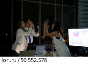 Group of broker international stock traders working actively at night in office, Everyone is congratulating the team on their success. Стоковое фото, агентство Ingram Publishing / Фотобанк Лори