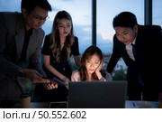 Group of broker international stock traders working actively at night in office, A young woman is working hustle to present a client with friends helping her with information. Стоковое фото, агентство Ingram Publishing / Фотобанк Лори