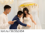 Bridal gown designers and tailors measure the size of the gown against the bride’s figure when she comes to try on the gown in order to make it perfect and ready to wear on the wedding day. Стоковое фото, агентство Ingram Publishing / Фотобанк Лори