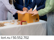 Group of owner small business Clothes are being packaged for delivery to customers in cardboard boxes and cushioned lump from natural materials that are not toxic to the planet. Стоковое фото, агентство Ingram Publishing / Фотобанк Лори