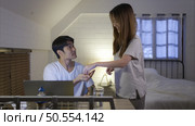 Young asian woman prepare medicine for husband who has a headache before working overtime at home tonight. Стоковое фото, агентство Ingram Publishing / Фотобанк Лори