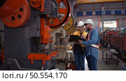 Engineer and technician discussing machinery in factory to plan inspection maintenance according to usage cycle, Concepts inspections based on usage cycle maintenance. Стоковое фото, агентство Ingram Publishing / Фотобанк Лори