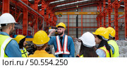 Supervisor and group of factory workers wearing hard hats meeting brief together before starting the day’s work. Стоковое фото, агентство Ingram Publishing / Фотобанк Лори