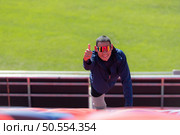 Disabled athletes prepare their bodies on amphitheater in a sports arena on a sunny day before entering a short-distance running competition. Стоковое фото, агентство Ingram Publishing / Фотобанк Лори