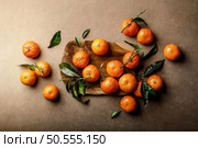 Mandarin oranges, clementines or tangerines with leaves on a dark background, top view. Стоковое фото, агентство Ingram Publishing / Фотобанк Лори