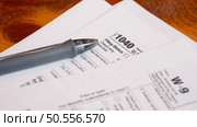 Tax form 1040 and W9 on a table, shallow depth of field. Стоковое фото, агентство Ingram Publishing / Фотобанк Лори
