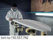 Surfboard manufacturing, Shaper working on board details. Concept of industrial manufacturing, qualified professional, occupation and employment. Стоковое фото, агентство Ingram Publishing / Фотобанк Лори