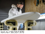Surfboard manufacturing, Shaper working on board details. Concept of industrial manufacturing, qualified professional, occupation and employment. Стоковое фото, агентство Ingram Publishing / Фотобанк Лори