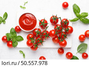 Tomato paste, sauce, ketchup and cherry tomatoes on branches and basil with copy space on white background, top view. Стоковое фото, агентство Ingram Publishing / Фотобанк Лори