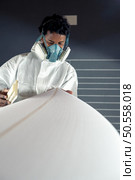 Surfboard manufacturing, Shaper working on board details. Concept of industrial manufacturing, qualified professional, occupation and employment. Стоковое фото, агентство Ingram Publishing / Фотобанк Лори