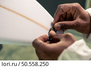 Surfboard manufacturing, Shaper working on board details. Concept of industrial manufacturing, qualified professional, occupation and employment. Стоковое фото, агентство Ingram Publishing / Фотобанк Лори