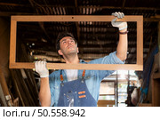 Carpenter working at his carpentry shop. Eyesight is utilized to ensure accuracy. Стоковое фото, агентство Ingram Publishing / Фотобанк Лори