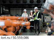 Group of engineers and technicians working together in a robotic arm factory. Inspecting robot arm before delivering to customers. Стоковое фото, агентство Ingram Publishing / Фотобанк Лори