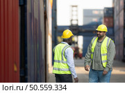 Both of workers in a container storage yard greeting each other during breaks in front of container warehouse, Стоковое фото, агентство Ingram Publishing / Фотобанк Лори