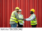 Group of workers in a container storage yard greeting each other during breaks in front of container warehouse, Стоковое фото, агентство Ingram Publishing / Фотобанк Лори