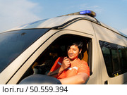 Portrait of paramedic team in ambulance use walkie talkie is assist an injured in an emergency situation on the road. Стоковое фото, агентство Ingram Publishing / Фотобанк Лори