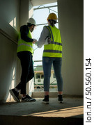 Engineer and architect working on the construction site, double-checking plans and process. Стоковое фото, агентство Ingram Publishing / Фотобанк Лори