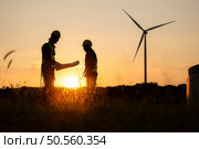 Silhouette of Engineer in charge of wind energy against a background of wind turbines. Стоковое фото, агентство Ingram Publishing / Фотобанк Лори