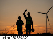 Silhouette of Engineer in charge of wind energy against a background of wind turbines. Стоковое фото, агентство Ingram Publishing / Фотобанк Лори