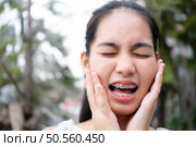 Portrait of a young asian woman with braces on her teeth. Стоковое фото, агентство Ingram Publishing / Фотобанк Лори