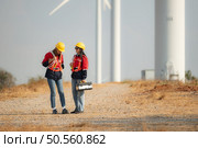 Both female engineers and wind turbines in a wind farm in the countryside of Thailand. Стоковое фото, агентство Ingram Publishing / Фотобанк Лори