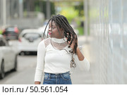 A young woman with his hairstyle and the atmosphere of living in the community. Стоковое фото, агентство Ingram Publishing / Фотобанк Лори