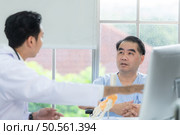In the hospital office, A medical explains about the foot bones and their treatment to a patient. Стоковое фото, агентство Ingram Publishing / Фотобанк Лори