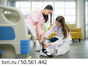 Following a period of treatment, the doctor examines the patient’s legs and knees. Стоковое фото, агентство Ingram Publishing / Фотобанк Лори