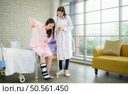 Following a period of treatment, the doctor examines the patient’s legs and knees. Стоковое фото, агентство Ingram Publishing / Фотобанк Лори