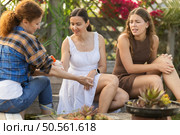 Women spray mosquito repellent on their legs and arms while working in farm and garden. Стоковое фото, фотограф Яков Филимонов / Фотобанк Лори