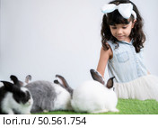 Smiling little girl and with their beloved fluffy rabbit, showcasing the beauty of friendship between humans and animals. Стоковое фото, агентство Ingram Publishing / Фотобанк Лори