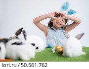 Smiling little girl and with their beloved fluffy rabbit, showcasing the beauty of friendship between humans and animals. Стоковое фото, агентство Ingram Publishing / Фотобанк Лори