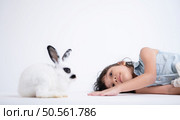 Smiling little girl and with their beloved fluffy rabbit, showcasing the beauty of friendship between humans and animals. Стоковое фото, агентство Ingram Publishing / Фотобанк Лори