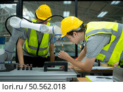Group of engineers and technicians learning the technology to control hand robots for industrial usage. Стоковое фото, агентство Ingram Publishing / Фотобанк Лори