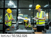 Group of engineers and technicians learning the technology to control hand robots for industrial usage. Стоковое фото, агентство Ingram Publishing / Фотобанк Лори